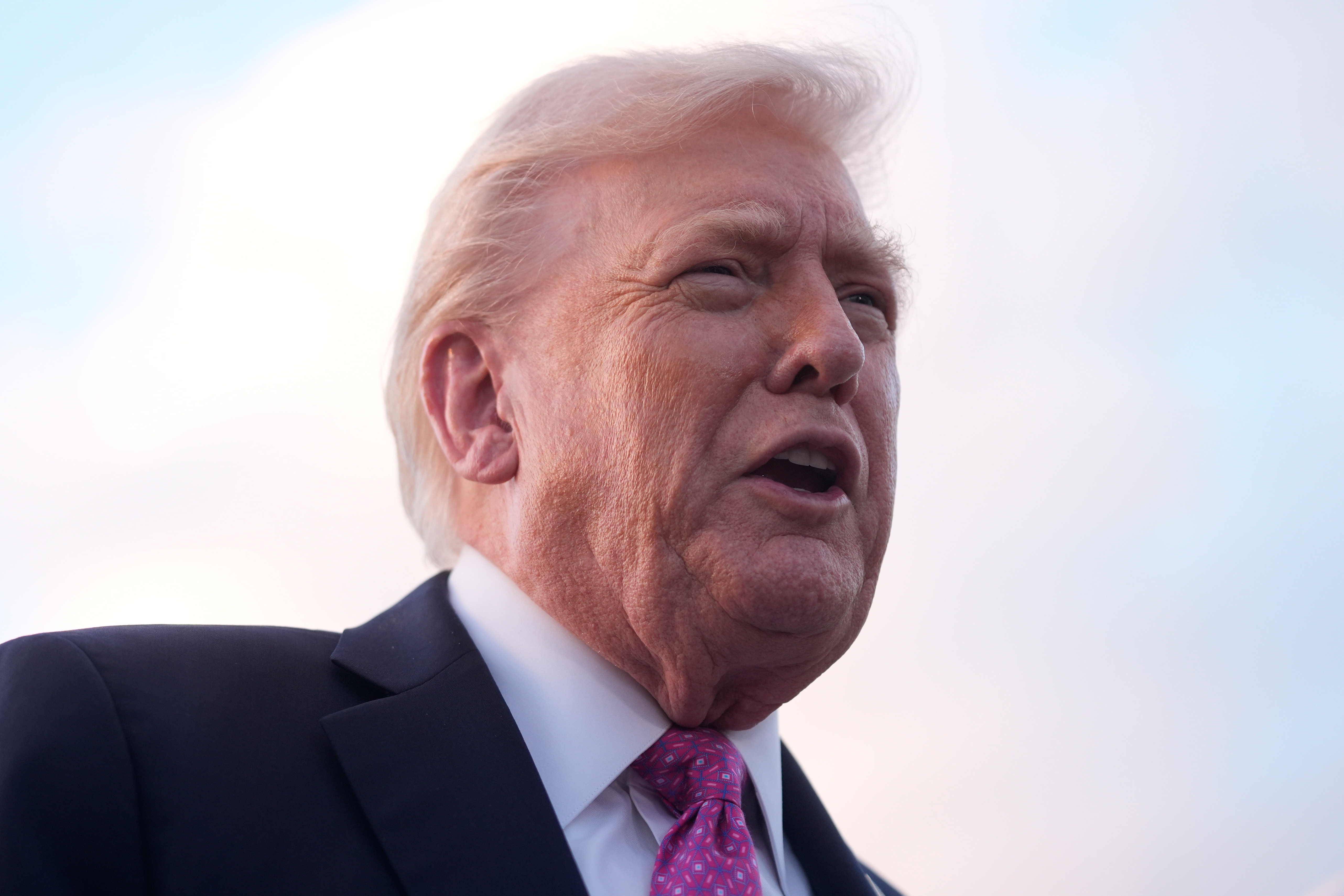 President Trump speaks to reporters after arriving on Air Force One, Friday, at Palm Beach International Airport in West Palm Beach, Fla.